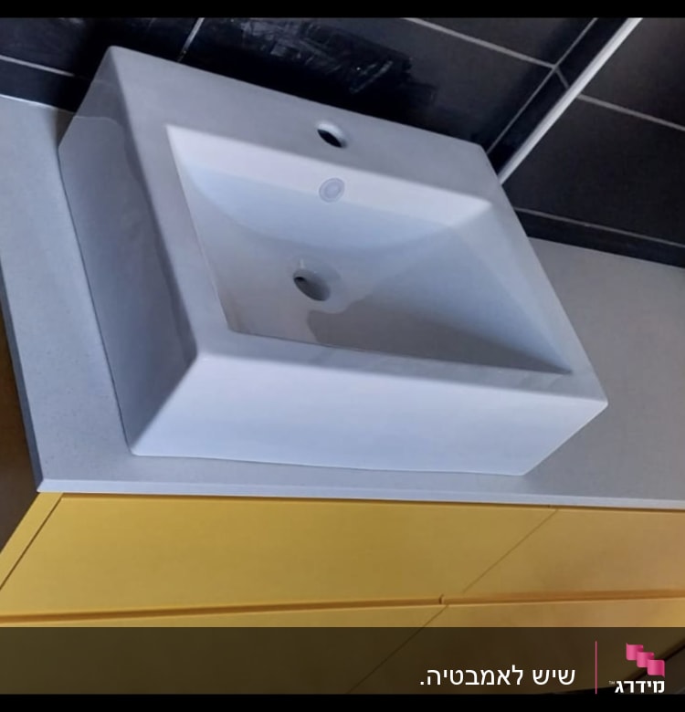 כיור על משטח שיש לבן בחדר אמבטיה